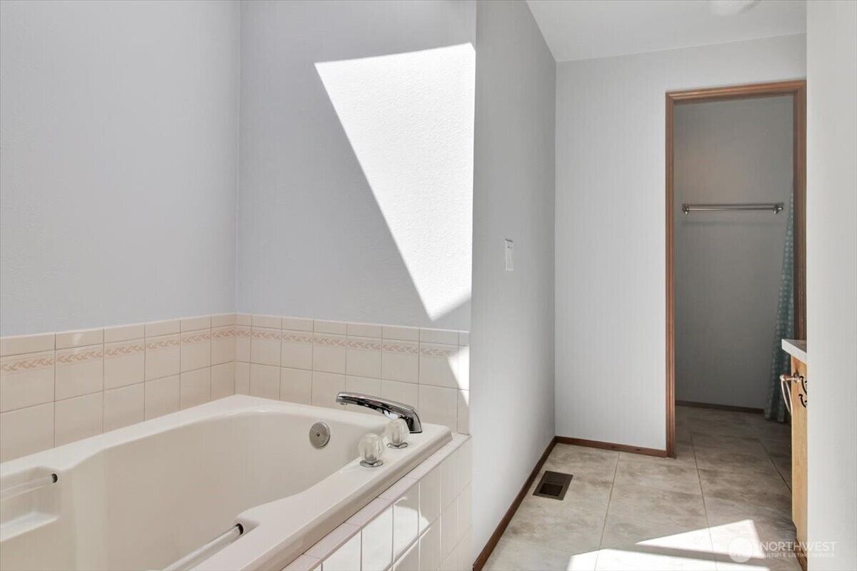 Primary bathroom with soaking tub and skylight