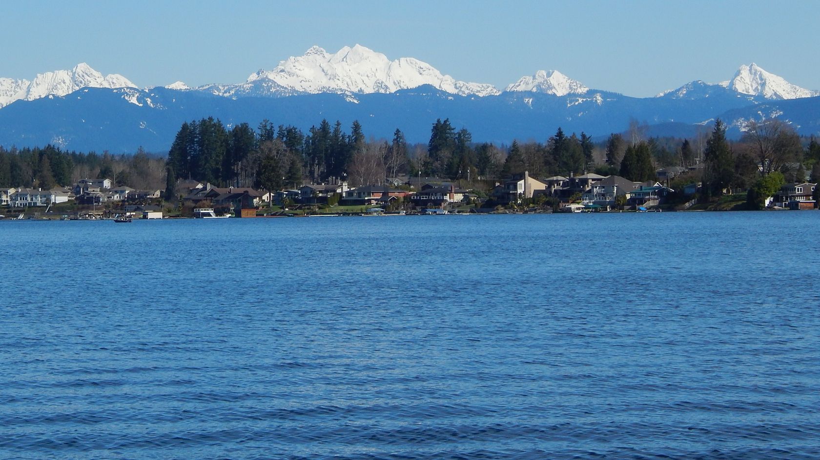 Lake Stevens seen from the shore, with homes along the water and the Cascades behind